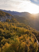 Sun shining over a wooded valley and mountain peaks in the background, Switzerland, Europe