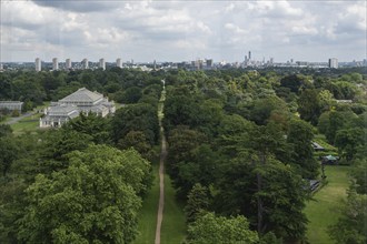 View from the large pagoda over a long path lined with trees and a greenhouse into the centre of