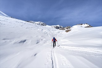 Ski tourers on an alpine tour on the Fürkeleferner glacier, snow-covered mountain landscape in