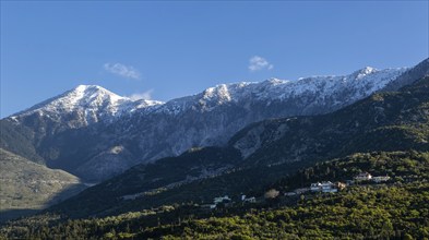 Snow capped peaks including Mount Cika rising above hillside village, Palase, near Dhermi, Albania,