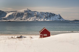 Red hut, snowy landscape, sea, mountains, Lofoten, Northern Norway, Norway, Europe