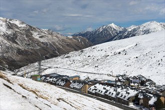 Ein Dorf in den schneebedeckten Bergen, mit einer Straße, Skigebiet, El Pas de la Casa,