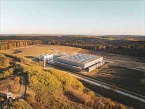 Industrial complex in the middle of an autumnal forest landscape seen from the air, Lindenrain