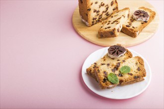 Homemade cake with raisins and dried persimmon on a pink pastel background. Side view, close up,