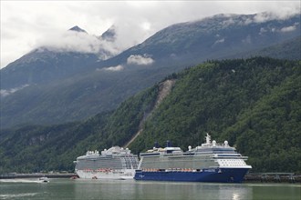 Two large cruise ships in front of high mountains in the harbour of Skagway, Alaska, USA, North