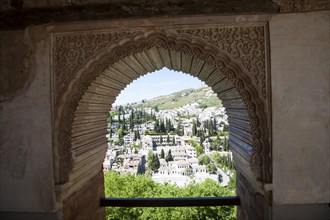 View through Alhambra window archway to Moorish houses in the Albaicin district of Granada, Spain,