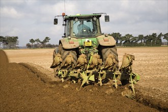 John Deere green tractor ploughing field, Shottisham, Suffolk, England, United Kingdom, Europe