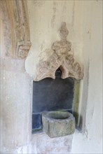 Holy water stoup bowl in porch entrance, village parish church of St James South Elmham, Suffolk,