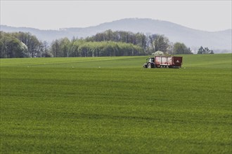 A tractor on a country road stands out in front of a field in Vierkirchen, 12.04.2024