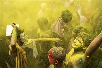 Revellers dancing in the beat of music as they celebrate Holi on a street, the Hindu spring