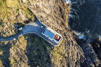 Aerial view of Krakenes Fyr lighthouse, lighthouse located on steep cliff, norwegian coast north of