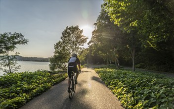 Cycling on Lake Baldeney, around 14 kilometres around the Ruhr reservoir, summer evening on the