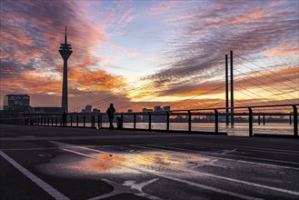 Winter sunset on the Rhine near Düsseldorf, riverside promenade at the old town, Rhine Tower, cargo