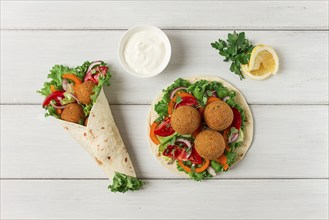 Tortillas, wrapped falafel balls, with fresh vegetables, vegetarian healthy food, on a wooden white