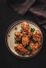 Fried chicken legs, breaded, with spices and herbs, on a dark background, vertical, no people,