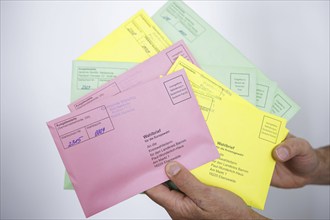 A man holds postal voting documents for the European elections, district council elections and