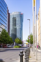 Street scene in a city with modern skyscrapers, glass facades and trees under a clear sky, Berlin,