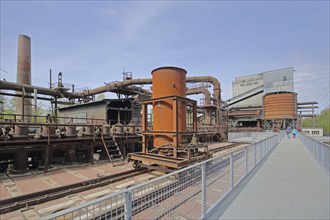 Coking plant with wagon on rails, pipelines, buildings and tourists, UNESCO Völklingen Ironworks,