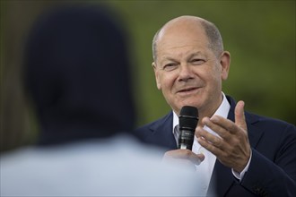 Olaf Scholz (Federal Chancellor, SPD) in conversation with a lady with a headscarf at the Germany