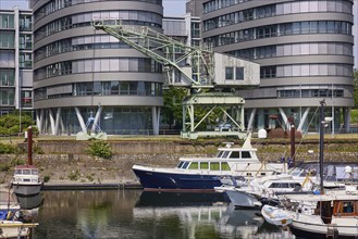 Historic crane in front of the Five Boats office building and the marina in the inner harbour of