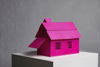 AI generated magenta paper house nestled against a dark grey backdrop