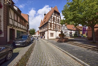 Historic town hall on Braunstraße with half-timbered houses, blue sky and cumulus clouds in