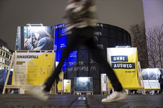 A person crosses the former strip of the Wall in front of the exhibition in front of the asisi