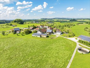 Aerial view of an extensive meadow landscape with a village and farms, glass fibre installation,