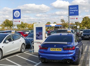 Electric vehicles charging Pod Point, Tesco Extra supermarket carpark, Swindon, Wiltshire, England,