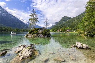 Hintersee near Ramsau with clear green water, surrounded by forests and mountains under a cloudy