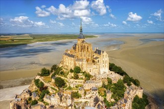 Historic abbey on a rocky island, surrounded by sandy beaches and blue skies, Le Mont-Saint-Michel