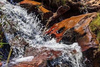 Water from a small waterfall splashing over rocks in Minas Gerais, Minas Gerais, Brazil, South