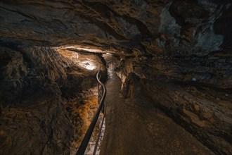 Dark cave path with flowing water and lighting, mysterious atmosphere, Beatus Caves, Switzerland,