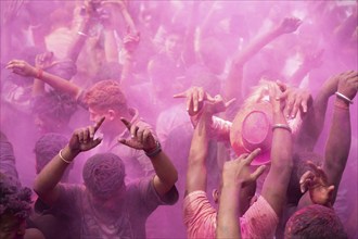 Revellers dancing in the beat of music as they celebrate Holi on a street, the Hindu spring