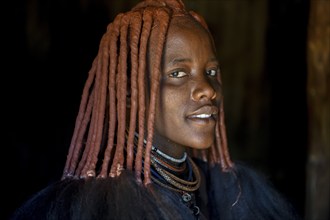 Young Himba woman in her hut, Ohandungu, Kunene region, Kaokoveld, Namibia, Africa