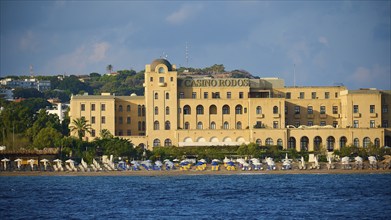 Casino building on the beach with parasols and clear sea, harbour area, Rhodes Town, Rhodes,