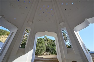 Interior of a white domed structure with large windows and bright light patterns on stairs, thermal