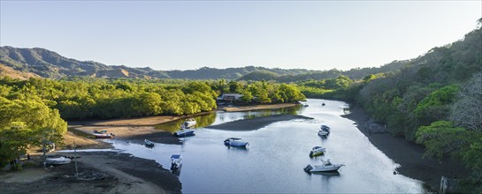 Aerial view of a peaceful estuary with boats surrounded by trees and greenery, Pochote, Puntarenas,