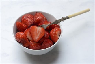 Halved strawberries in a bowl, Fragaria