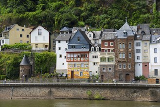 Various historic buildings and houses along the green riverbank in a picturesque village, Cochem,