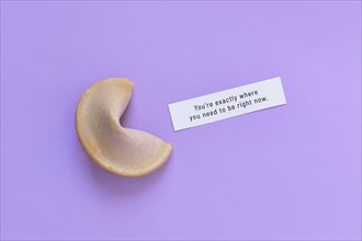 Fortune cookie with motivational text on paper saying 'You're exactly where you need to be right