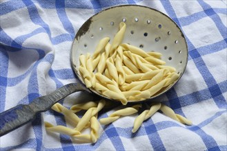 Strozzapreti, uncooked Italian pasta in a sieve, Italy, Europe