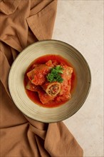 Stuffed cabbage rolls, with minced meat, in tomato sauce, on a beige background, food and drink,