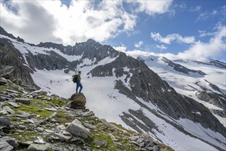 Mountaineer on a rock, rocky mountain peak Furtschaglspitze in the background, glaciated peak