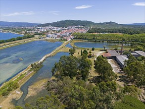 Aerial view of a peaceful natural environment with river, hills, forests and a small town in the