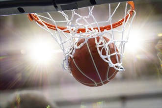 Close-up of a basketball landing in the hoop