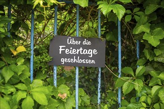 Symbolic picture company holidays: Sign on the garden with the inscription CLOSED OVER THE HOLIDAYS