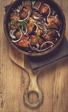 Fried meat, pork kebab, ketsi in a clay pan, with red onions and herbs, homemade, no people