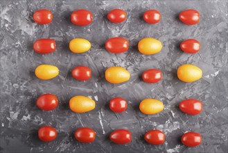 Rows of cherry tomatoes and kumquats on a black concrete background, top view, flat lay. contrast