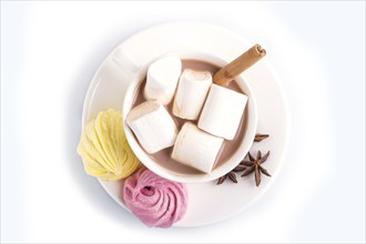 A cup of hot chocolate with marshmallow, meringue and spices isolated on white. closeup. top view